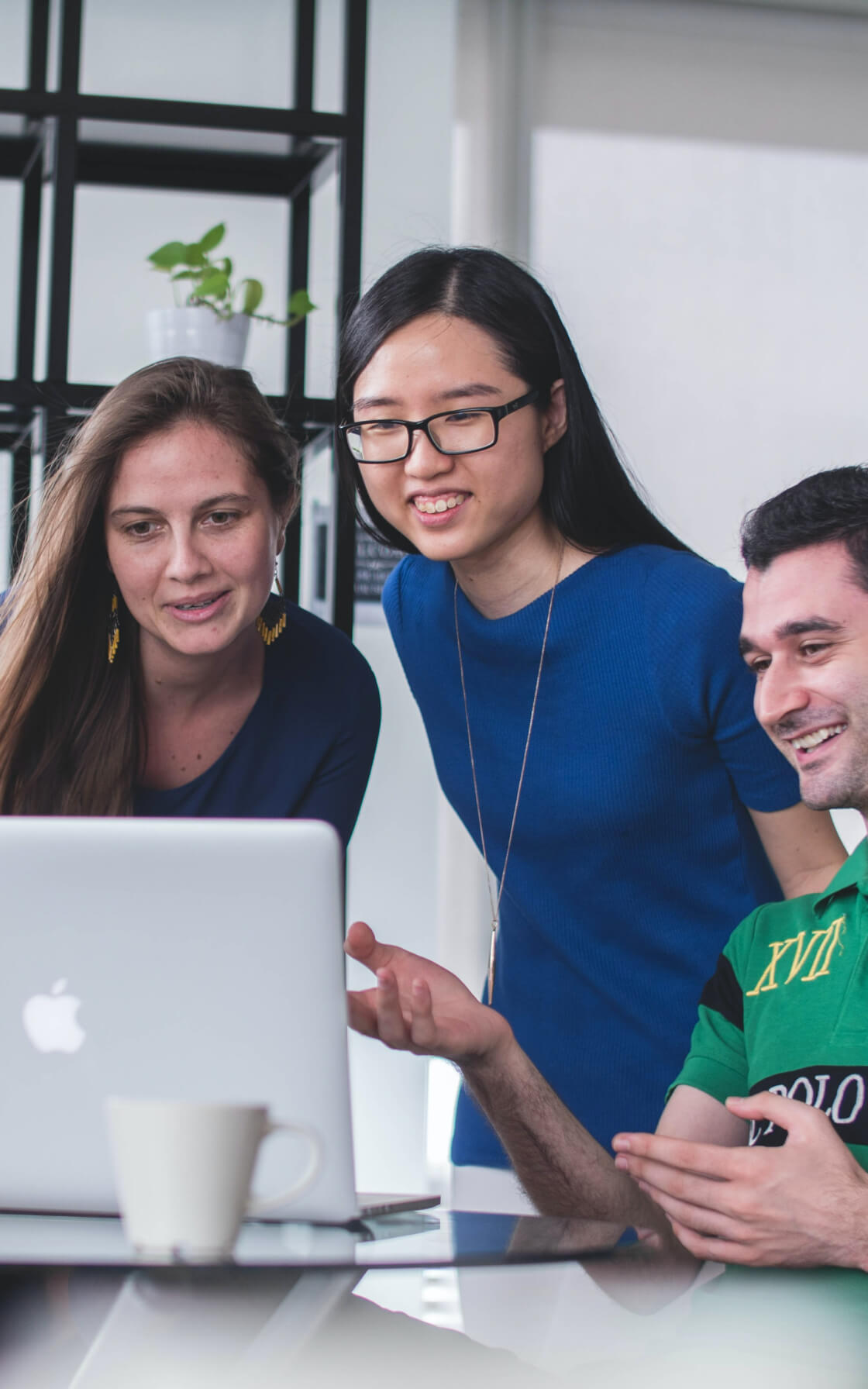 3人の男女がパソコンに向かい談笑している様子